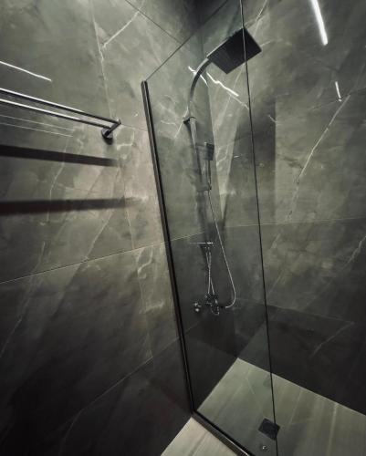 a shower with a glass door in a bathroom at Baja Suites in Kalamata