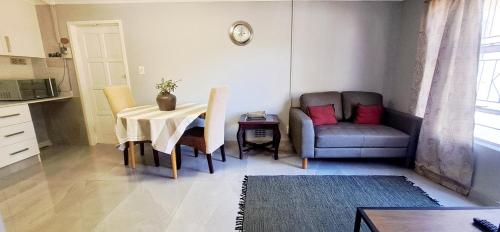 un soggiorno con un tavolo e una sedia di Waterfall City Guest Lodge a Sandton