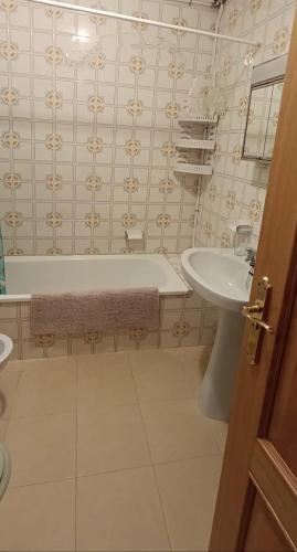 a bathroom with a tub and a sink and a toilet at Vistas pedras neg in Pontevedra
