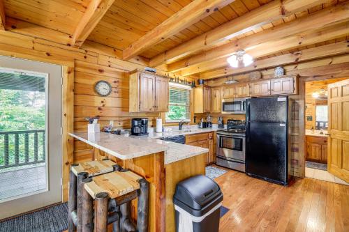 a kitchen with wooden cabinets and a black refrigerator at Pigeon Forge Cabin Premier Location and Hot Tub in Pigeon Forge