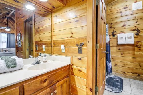 a bathroom with a sink and a mirror at Pigeon Forge Cabin Premier Location and Hot Tub in Pigeon Forge