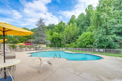 a swimming pool with a table and chairs and an umbrella at Pigeon Forge Cabin Premier Location and Hot Tub in Pigeon Forge