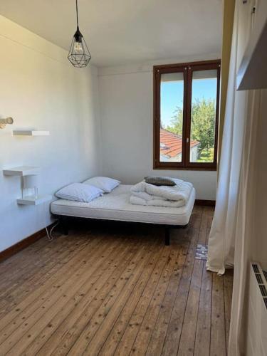 Cette chambre comprend un lit et une fenêtre. dans l'établissement De bric et de broc , maison à 100m plage, à Asnelles