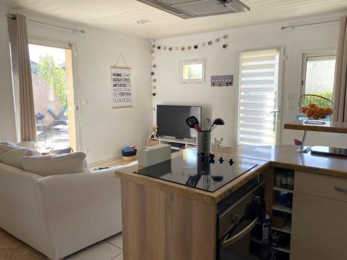 a kitchen and living room with a couch and a table at De bric et de broc , maison à 100m plage in Asnelles