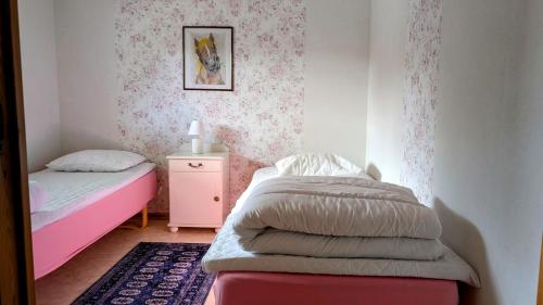 a small bedroom with a bed and a night stand at Rolig häst, Kaneeling Stugby AB in Dalskog