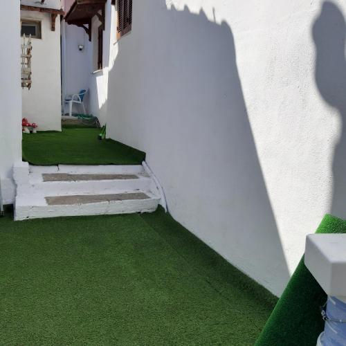 a white building with green flooring and stairs at Hippocampus House in Stratónion