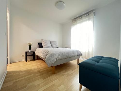 une chambre avec un lit et un canapé bleu dans l'établissement Appartement des Lilas 25km de Paris et Disney, à Pontault-Combault