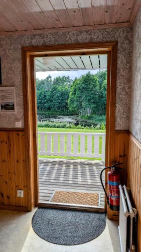 an open door with a view of a porch at Rolig häst, Kaneeling Stugby AB in Dalskog