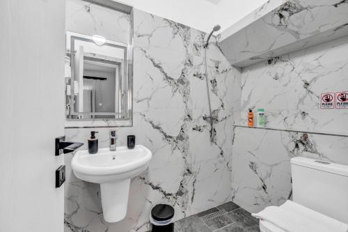 a white bathroom with a sink and a mirror at Nika's Guest House in Berat