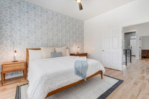 a bedroom with a large white bed and a hallway at Vista Montana Downtown Monument w BBQ & Fire Pit in Monument
