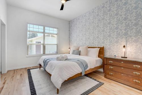 a bedroom with a bed and a dresser and a window at Vista Montana Downtown Monument w BBQ & Fire Pit in Monument