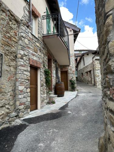a stone building with a balcony on the side of it at Nel Caruggio - B&B in Mornese