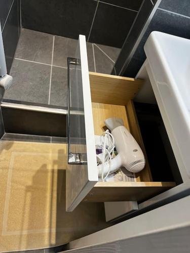 un meuble de cuisine avec un tiroir avec un sèche-cheveux dans l'établissement Appartement Neuf Côté La Défense, à Courbevoie