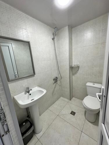 a bathroom with a sink and a toilet and a mirror at Hotel black sea in K'obulet'i