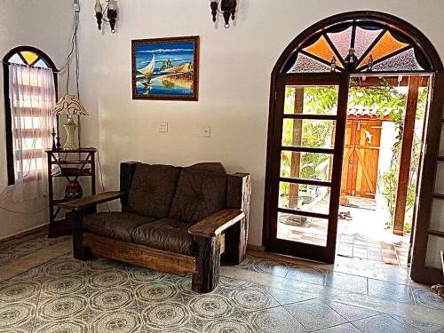 a living room with a couch and an open door at Casa Grande com 3 suítes in Peruíbe