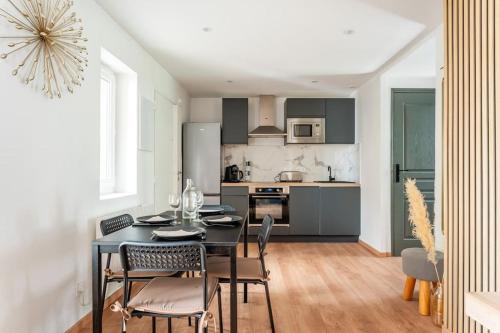 une salle à manger avec une table et des chaises dans une cuisine dans l'établissement Le Séduisant T2/terrasse, Notre Dame de la Garde, à Marseille