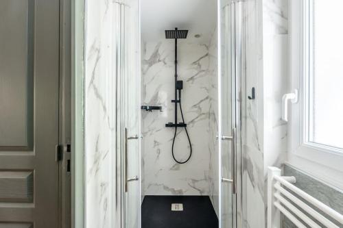 La salle de bains est pourvue d'une douche et de toilettes noires. dans l'établissement Le Séduisant T2/terrasse, Notre Dame de la Garde, à Marseille