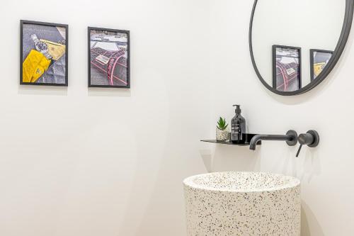 a bathroom with a round mirror and a sink at Goldie&Leon rooms Cernobbio in Cernobbio