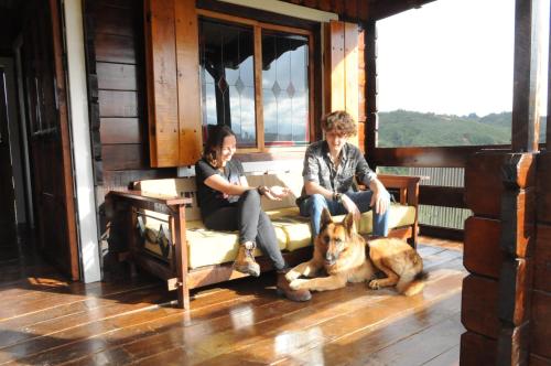two people sitting on a porch with a dog at Hoguera del Nómada in Santo Domingo