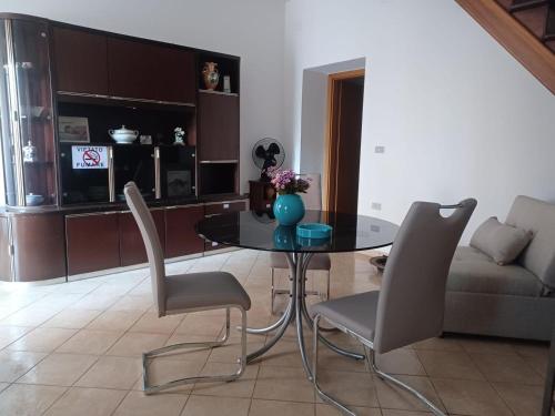 a dining table and chairs in a living room at Appartamento 140 mq a pochi minuti da Tropea, 2 bagni in Le Pioppe