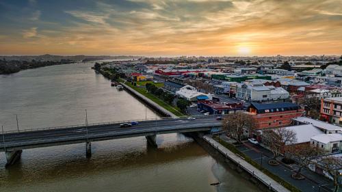 a view of a city with a bridge and a river at Johnston Apartments - Award-winning building, Your unforgettable stay in Whanganui