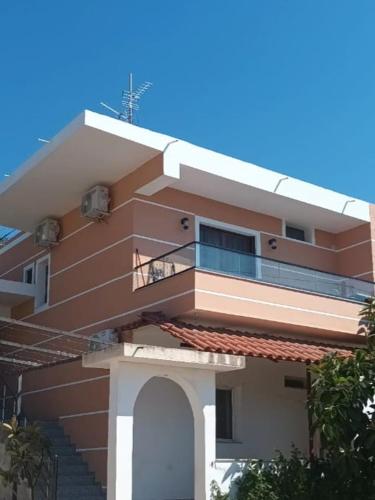 a tall building with a balcony and a blue sky at Miri's Villa in Sarandë