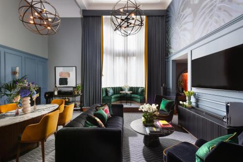 a living room with a couch and a tv at Kimpton Clocktower by IHG in Manchester