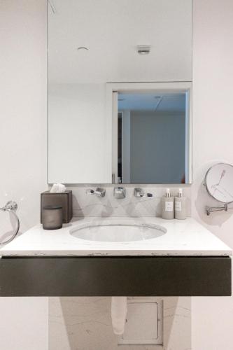 a white bathroom with a sink and a mirror at Hotel Zena Washington DC in Washington