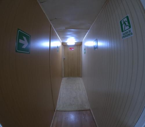 a hallway with a wooden door in a building at Hostel 53 Sur in Puerto Natales