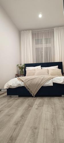 a bedroom with a bed and a wooden floor at CITY VIEW Saperów - parter, przy centrum in Świdnica