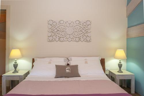 a bedroom with a large bed with two lamps at Palascìa Wellness Relais in Otranto