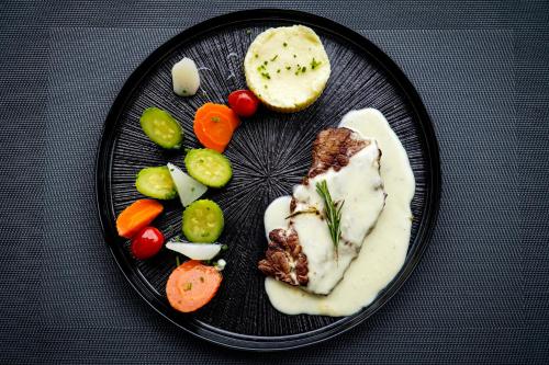 a plate of food with meat and vegetables on it at AZ hôtel des arts in Rabat