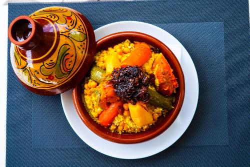 a bowl of food on a plate next to a cup at AZ hôtel des arts in Rabat