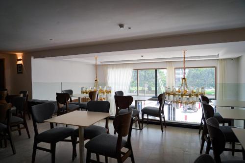 a restaurant with tables and chairs and a large window at AZ hôtel des arts in Rabat
