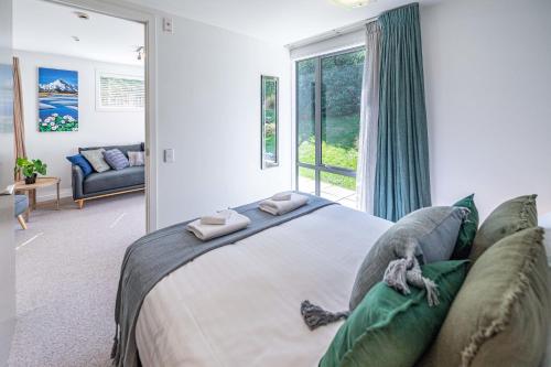 a bedroom with a large bed and a large window at Central Luxury Apartment 114 in Wanaka