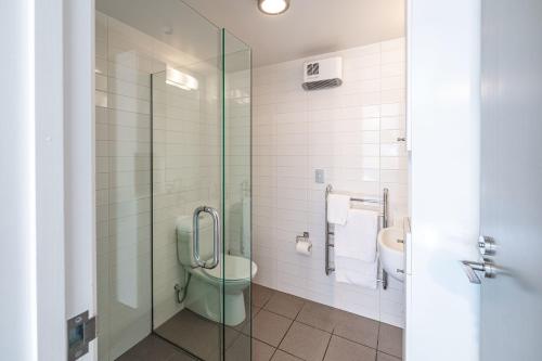 a bathroom with a green toilet and a glass shower at Central Luxury Apartment 114 in Wanaka