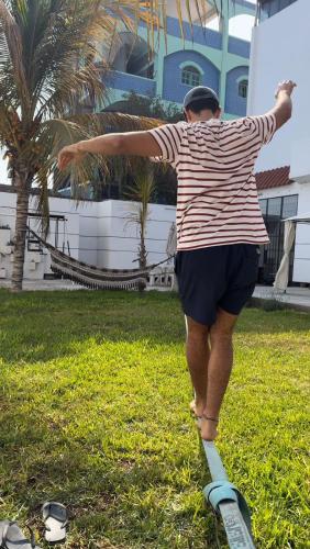 a man standing on a skateboard in the grass at La Arteza Pacasmayo in Pacasmayo