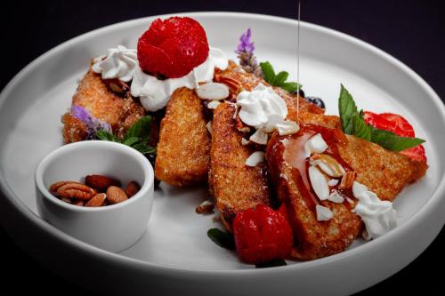 a plate of food with french toast and strawberries and nuts at Cantera 1910 Hotel Boutique, Destination Hotel in San Miguel de Allende