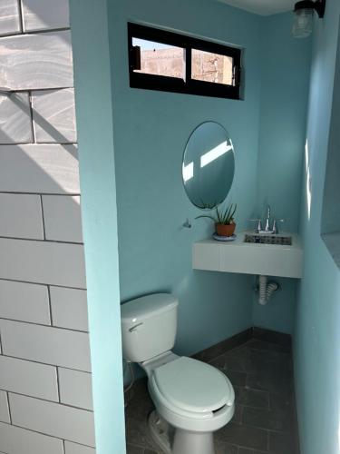 a blue bathroom with a toilet and a mirror at Depas Azules Zona Centro Apt B in Mazatlán