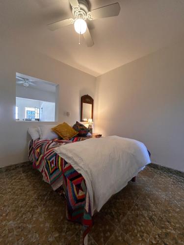 a bedroom with a bed with a ceiling fan at Depas Azules Zona Centro Apt B in Mazatlán
