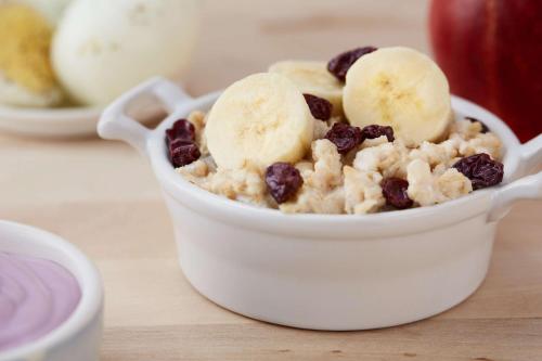 a bowl of oatmeal with bananas and raisins at Drury Plaza Hotel Nashville Franklin in Franklin