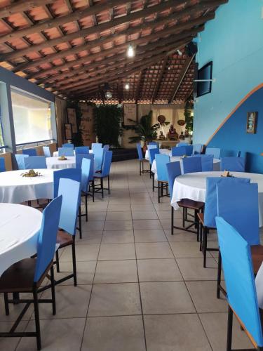 een eetkamer met witte tafels en blauwe stoelen bij Recanto Paraíso Aventuras in Rio Negrinho