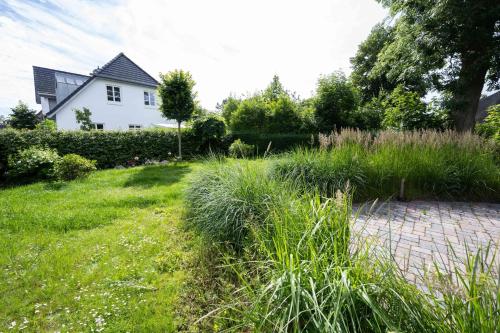 ogród z domem i ceglaną ścieżką w obiekcie Haus Frida w mieście Wyk auf Föhr