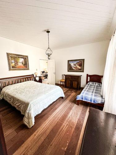 a bedroom with a bed and a table in it at Fazenda com fácil acesso - Piscina e churrasqueira in Biritiba-Mirim