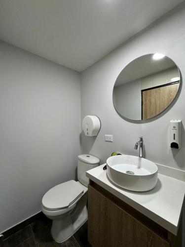 a bathroom with a toilet and a sink and a mirror at Hostelfc Usaquen in Bogotá