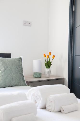 a bedroom with a bed with towels on it at Stylish Home, hosted by ESONGRACE Stays, Stoke-on-Trent - Perfect for Families - Contractors - Holiday makers - Emergency Housing - Professionals, Relocators in Stoke on Trent