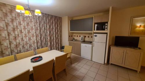 une cuisine et une salle à manger avec une table et un réfrigérateur dans l'établissement Cap d Agde Rochelongues, au Cap d'Agde