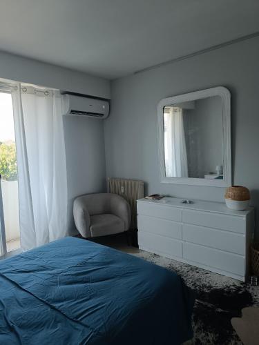 une chambre avec un lit, un miroir et une chaise dans l'établissement Magnifique 2 pièces vue mer, à Cannes