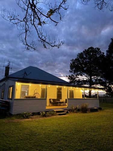 a yellow house with lights on the side of it at Farm stay on the river in Langley Vale