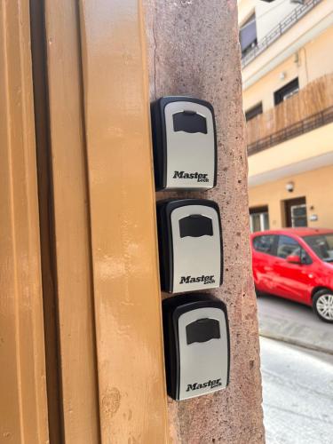 a close up of three parking meters on a pole at Aurora Apartments in Mytilini